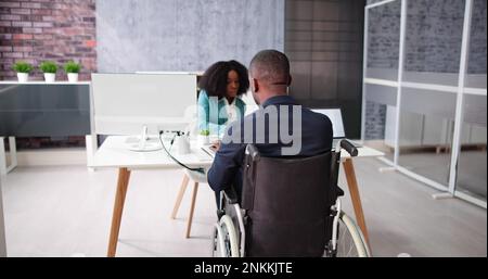 Two Young Businesspeople Working On Laptop At Workplace Stock Photo