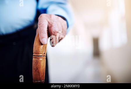 Steadily walking back to good health. Closeup shot of an unrecognizable senior mans hand holding onto a walking stick. Stock Photo