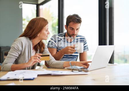Theyve got bills to pay. a young couple working on their household budget and paying bills online. Stock Photo