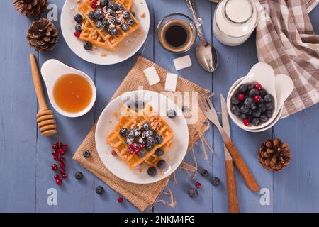 Waffles with red currant and blueberries on white dish. Stock Photo