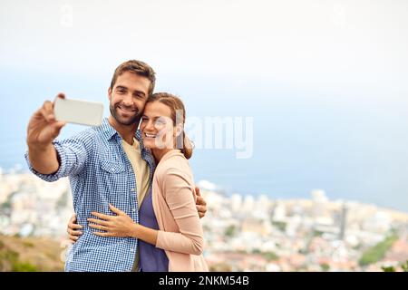Selfies make the date feel more special. an affectionate couple taking selfies outside. Stock Photo