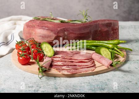 Smoked beef tongue. Sliced Smoked Veal Tongue on Wooden Cutting Board. Delicious smoked meat. Local name fume dana dil Stock Photo