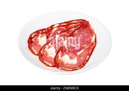 Beef ribeye pastrami isolated on white background. Dried Turkish bacon slices in plate. Traditional Turkish delicacies Stock Photo