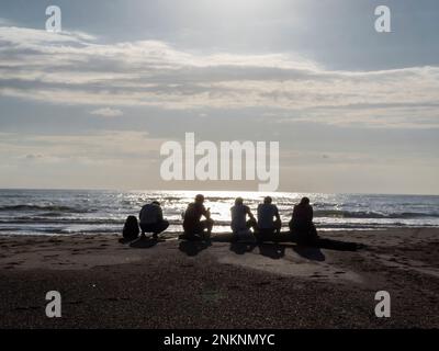 Five people wait for the sun to set before going fishing in Samara Costa Rica Stock Photo