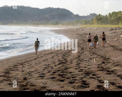 People walking along a beach near Samara in Costa Rica Stock Photo