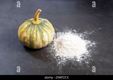 all-purpose flour powder and pumpkin fruit on a black background. Stock Photo