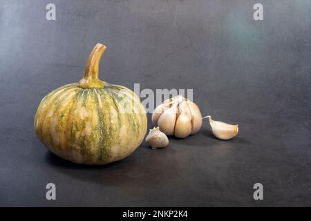 Raw pumpkin and garlic vegetable on a dark background. Stock Photo