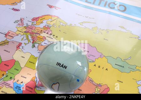 Crystal ball on a world map that highlights a country to highlight it as a magnifying glass and note its economic and financial importance: Iran Stock Photo