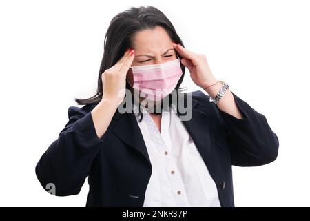 Female business corporate wearing medical or surgical protective mask touching temples having headache as flu cold covid19 infection symptom isolated Stock Photo