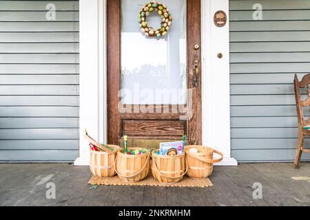 Four Easter baskets lined up on porch in front of front door Stock Photo