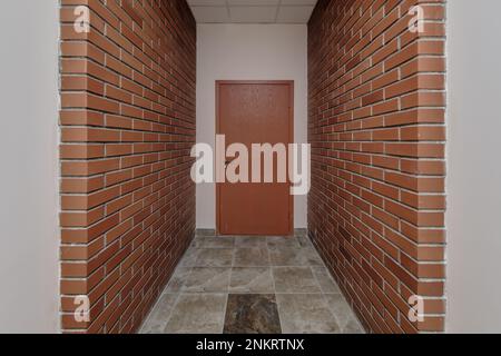 white empty long corridor with red brick walls for room office in interior of modern apartments, office or clinic Stock Photo
