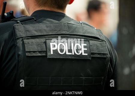 Whitehall, London, UK. 16th July 2016. Police logo patch, being worn on the rear of a bullet proof vest by a Metropolitan police officer in London. Stock Photo