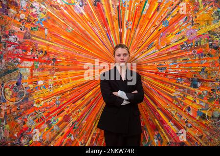 London, UK.  24 February 2023. A staff member with “Adieu Interessant (orange)”, by Tal R (Estimate £60,000 - 80,000) at a preview of Phillips’ upcoming sales of 20th Century and Contemporary Art.  Highlights include works by Gerhard Richter, Willem de Kooning, Jean Dubuffet, Albert Oehlen, Cecily Brown and Claire Tabouret.  The sales take place at Phillips’ Berkeley Square galleries on 2 and 3 March 2023. Credit: Stephen Chung / Alamy Live News Stock Photo