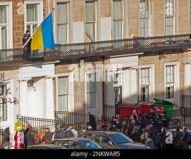 Ukrainian Consulate, Edinburgh, Scotland, UK. 24 February 2023. A small crowd gathers to mark  the 1st anniversary since Russia’s invasion of Ukraine. Pictured: Flag raising and moment of silence-Ukrainian Consulate, Windsor Street Edinburgh, Scotland, UK. Credit: Archwhite/alamy live news. Stock Photo