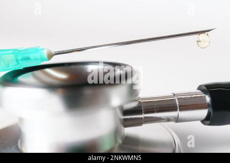 close-up of a syringe needle with a droplet falling on a white background Stock Photo
