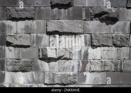 Smooth and untreated gray rectangular granite stone wall, rubblework. Stock Photo