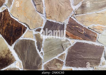 Wall with irregularly shaped brown tiles. Stock Photo