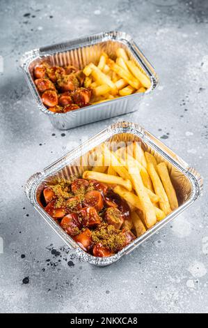 Traditional German currywurst with french fry served take away. Gray background. Top view. Stock Photo