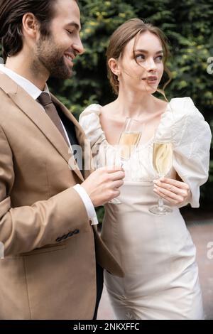 Bride and groom are holding champagne glasses Stock Photo - Alamy