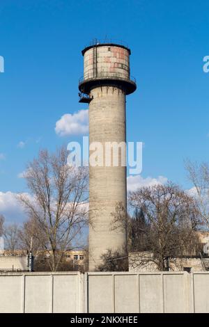 Concrete gray water tower on a blue sky. Stock Photo