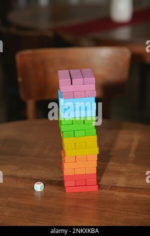 A young couple of a guy and a girl play colored jenga. Stock Photo