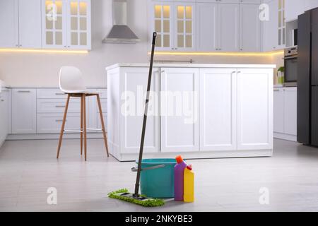 Floor mop, bucket and cleaning products in kitchen Stock Photo