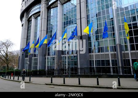 Brussels, Belgium. 24th Feb, 2023. Flags of Ukraine and EU fly in front of the EU Parliament building on the first anniversary of the Russian invasion, in Brussels, Belgium February 24, 2023 Credit: ALEXANDROS MICHAILIDIS/Alamy Live News Stock Photo