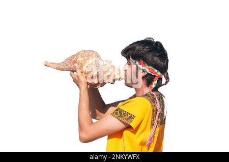 Mexican man in traditional costume in profile plays sea shell with white background Stock Photo