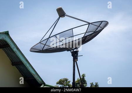 Big C-Band Satellite dish on roof of a house. Option to get free cable TV signal. Stock Photo