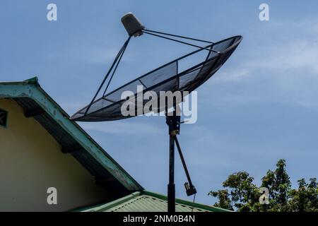 Big C-Band Satellite dish on roof of a house. Option to get free cable TV signal. Stock Photo