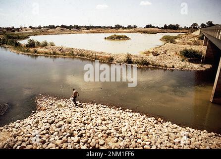 1970s United States:  Worker taking samples of water polluted from gravel plant upstream  ca.  1972 Stock Photo