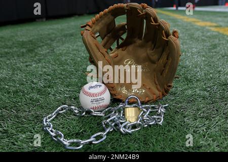A baseball sits on a glove, with a lock and chain representing the lockout  between Major League Baseball (MLB) and the Major League Baseball Players  Association (MLBPA) on February 16, 2022, in