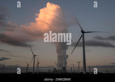 A cloud of steam from the cooling towers piles up above near wind power turbines at the Niederaussem lignite-fired power plant in Pulheim, Germany, Monday, Jan. 10, 2022. (Federico Gambarini/dpa via AP)