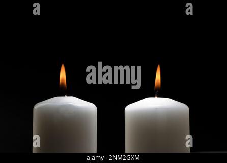 Two burning candles on a black background, couple Stock Photo