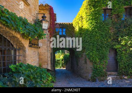 Street of the medieval historical center of Peratallada with houses covered with plants. Peratallada, Catalonia, Spain Stock Photo