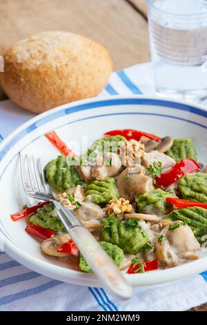 Spinach gnocchi with mushrooms and bell pepper Stock Photo