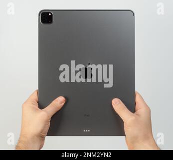 New york, USA - February 23, 2023: Rear view of ipad pro in hands isolated on white studio background Stock Photo