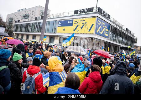 Berlin, Germany. 24th Feb, 2023. Participants of a demonstration under the slogan 'We will never forget' stand on Karl-Marx-Allee in front of Cafe Moscow, which for a few days was renamed Cafe Kyiv (Kiev). The Russian army had invaded Ukraine on 24.02.2022. Credit: Fabian Sommer/dpa/Alamy Live News Stock Photo