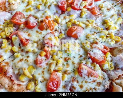 pizza with ham, mozzarella, corn and tomatoes Stock Photo