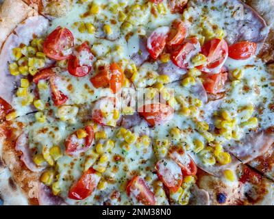 pizza with ham, mozzarella, corn and tomatoes Stock Photo