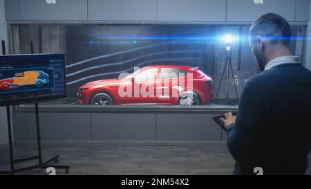 Testing aerodynamics of new generation eco-friendly electric car in lab using wind tunnel with steam. Digital tablet, LED screen with vehicle 3D model. Concept of car testing and modern technologies. Stock Photo