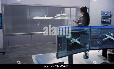 Engineers check aerodynamics of new development drone in laboratory for modern modifications using wind tunnel with steam. Computer system for changing parameters. Concept of manufacturing UCAVs. Stock Photo
