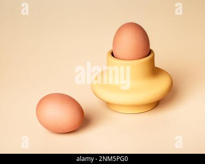Natural unpainted undyed chicken egg in holder, cup. Monochrome composition of healthy food. High quality photo Stock Photo