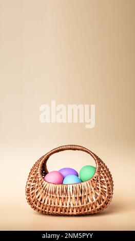 Easter eggs dyed, painted in pastel blue color in wicker basket with handle. Spring holiday card, banner, vertical background. High quality photo Stock Photo