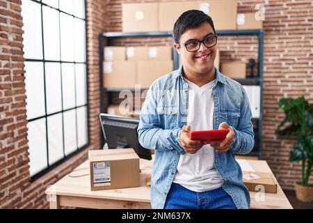 Down syndrome man ecommerce business worker using touchpad at office Stock Photo