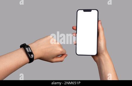 Premium PSD | Smart phone mockup. girl is looking at a smart bracelet.  concept of using health apps