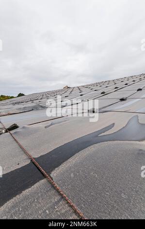 Weighted plastic sheeting covers a hillside in an active landfill.  Probably PVC geomembranes. Stock Photo