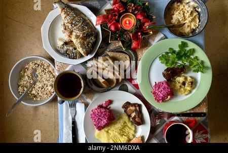 Christmas treats on the table, mashed potatoes, fried fish, appetizers and salads, top view Stock Photo