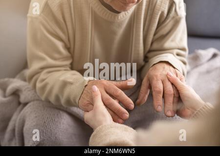 Head shot old male pensioner involved in rehabilitation procedure with caring young physiotherapist. retired man with walking disability feeling Stock Photo