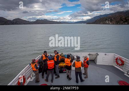 Hikers in a Catamaran, crossing Grey lake between Refugio Grey and Hotel Lago Grey, Torres del Paine national park, Patagonia, Chile Stock Photo